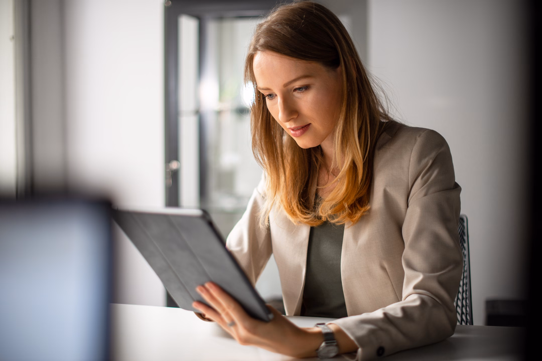 Business program participant reviewing a case brief on a tablet in a bright study room.